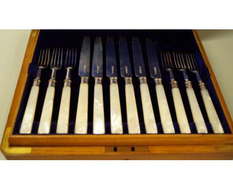 An oak cased set of twelve pairs of silver dessert knives and forks, by James Dixon & Sons, Sheffield 1900-1911, having mothe