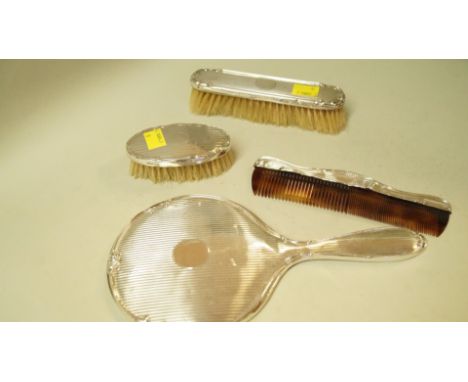 A silver three piece dressing table set, by R W E Ltd, Birmingham 1925, comprising: hand mirror; comb and hair brush; togethe