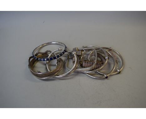 Three silver bangles set stones; together with a square hinged silver bangle; and seven other bangles.