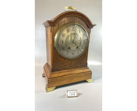 Early 20th century oak bracket clock with silvered Arabic face and two train German movement striking on one gong, brass loop