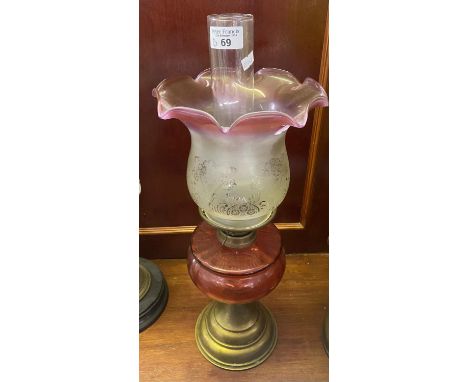 Early 20th Century double oil burner lamp having frosted and cranberry shade above cranberry reservoir on a brass base. (B.P.