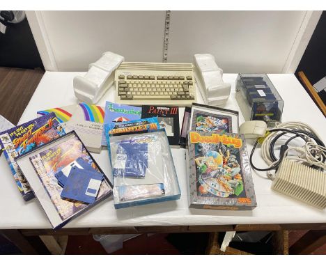 A commodore A600 computer console with power pack and selection of games,discs and books