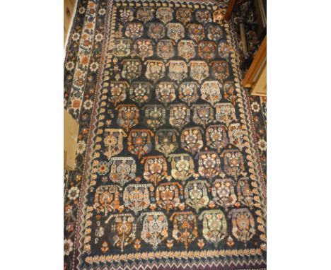 A Caucasian carpet, the central panel set with a repeating stylised motif decoration on a dark black ground within a stepped 