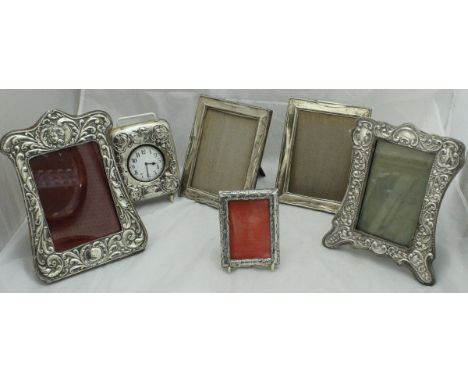 A pair of silver photo frames, together with two further photo frames with embossed C scroll and floral decoration, a smaller