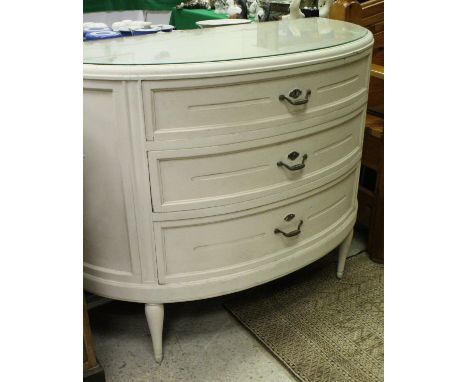 A white painted bow fronted three drawer commode in the French taste