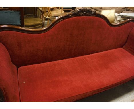 A 19th Century walnut framed sofa in red upholstery, raised on carved cabriole legs