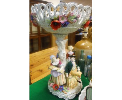 An East German porcelain table centre, the floral lattice work encrusted bowl raised upon a branch surrounded by four harvest