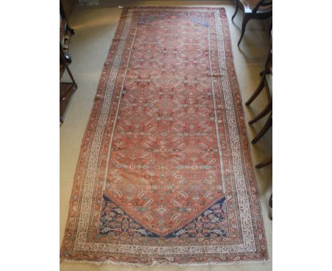 A Caucasian carpet, the central panel set with all over decoration on a red ground, within a stepped red, cream and yellow ge