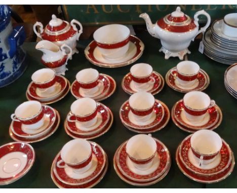 An early 20th century tea service, having deep red and gilt decoration, comprising: teapot, twin handled covered sugar bowl, 