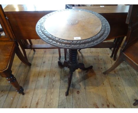 A late Victorian circular occasional table, having central walnut panel flanked by stepped relief decoration over spiral twis
