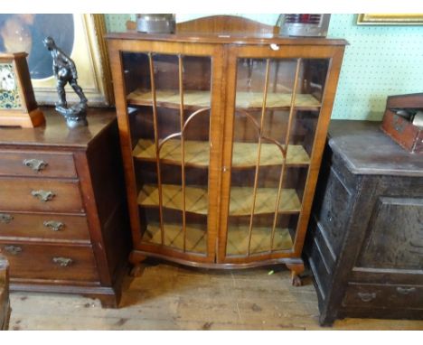 A mid-20th century bow fronted panel glazed display cabinet (89cm wide).