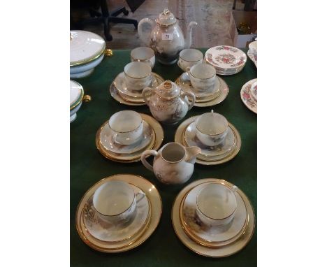 A Japanese export eggshell tea service, comprising: teapot, milk jug, sugar bowl, cups, saucers and side plates, each decorat