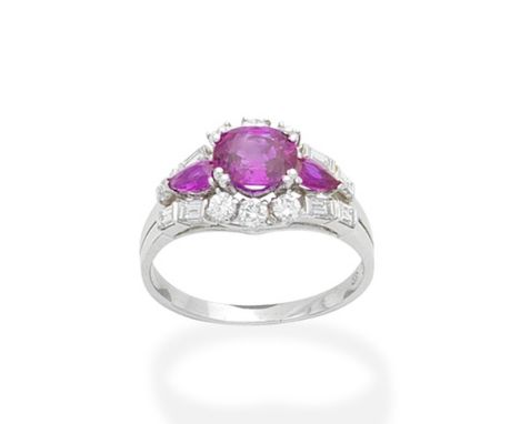 A ruby and diamond ringSet with an oval-cut ruby with a pear-shaped ruby to either side, within a brilliant and step-cut diam