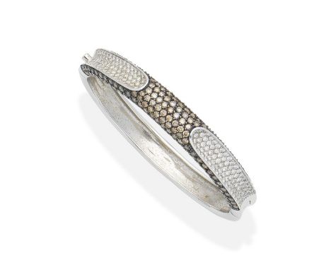 A diamond and coloured diamond bangleOf bombé form, set to the front with brilliant-cut diamonds of brown tint, with two conc