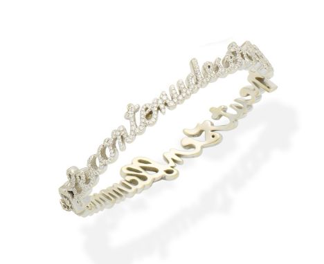 An 'Ecriture' bangle, by Lorenz BäumerDesigned as a line of script reading 'le contenu de cet objet peut s'enflammer', set th