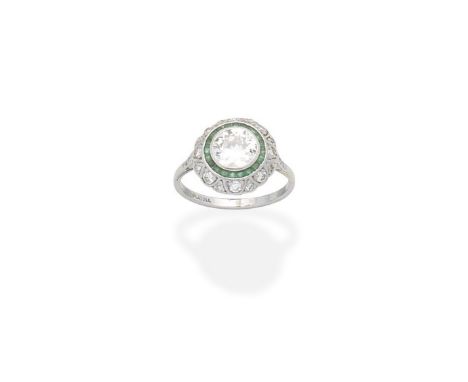 An emerald and diamond cluster ringOf target design, the old brilliant-cut diamond within a calibré-cut emerald, brilliant an