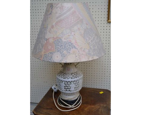 A Chinese-style pierced white glazed table lamp, and shade