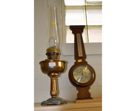 A Comitti of London oak cased wheel barometer, and a brass Aladdin paraffin lamp