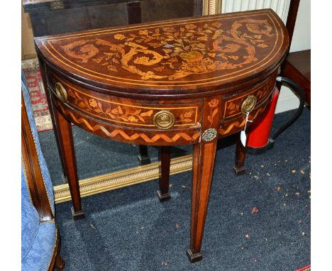 An early 19th century Dutch mahogany and floral marquetry demi-lune gaming table, the hinged top opening to reveal an inlaid 