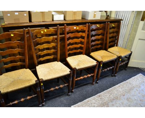 A part set of seven 18th century style wavy ladder back rush seated dining chairs