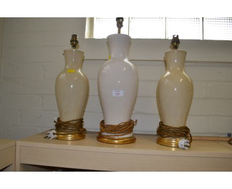 A pair of baluster caramel glazed table lamps, and a similar larger white glazed lamp