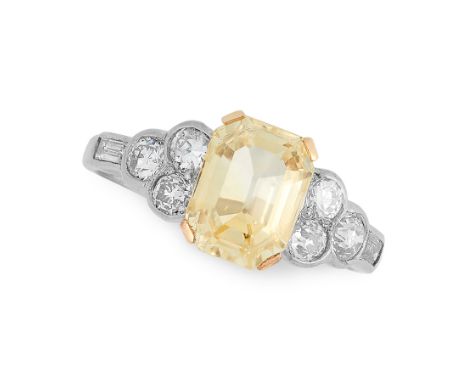 A YELLOW SAPPHIRE AND DIAMOND RING in platinum, set with an emerald cut yellow sapphire of 2.96 carats between trios of round