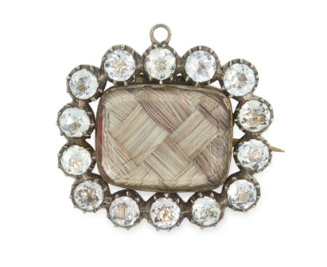 AN ANTIQUE PASTE AND HAIRWORK MOURNING BROOCH, 19TH CENTURY in silver, set with a central panel of woven hair work behind gla