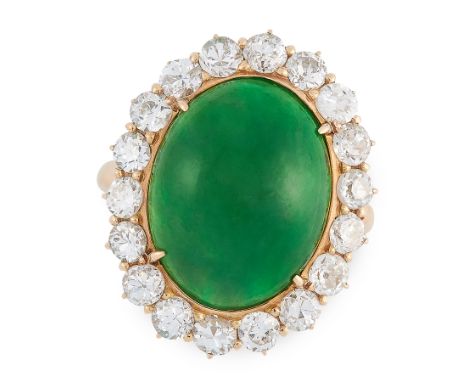 A JADEITE JADE AND DIAMOND RING in 18ct yellow gold, set with an oval jadeite cabochon of 12.40 carats, within a border of ro