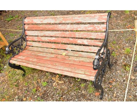 A TEAK SLATTED AND WROUGHT IRON GARDEN BENCH with lions head