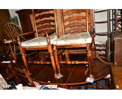 A REPRODUCTION OAK OVAL TOPPED DROP LEAF TABLE, with a single drawer, and four rush seated ladder back chairs including one c