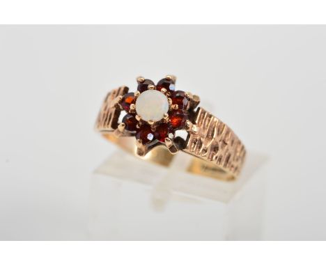 A 9CT GOLD OPAL AND GARNET CLUSTER RING, designed as a central circular opal cabochon within a circular garnet surround to th