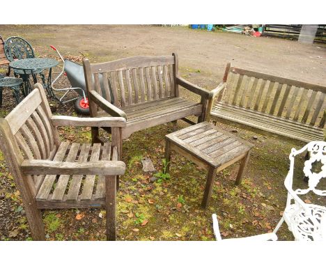 A TEAK SLATTED BRIDGEMAN GARDEN BENCH with a matching chair and coffee table, together with another teak slatted bench (4)