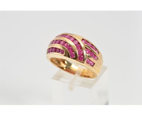 A 9CT GOLD RUBY DRESS RING, the wide tapered band channel set with curved and graduated rows of circular rubies, with 9ct hal