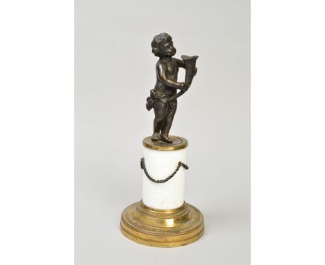 A SMALL BRONZE CHERUB FIGURE, holding a horn shaped shell, on a brass/ceramic plinth, approximate height 23.5cm (total)