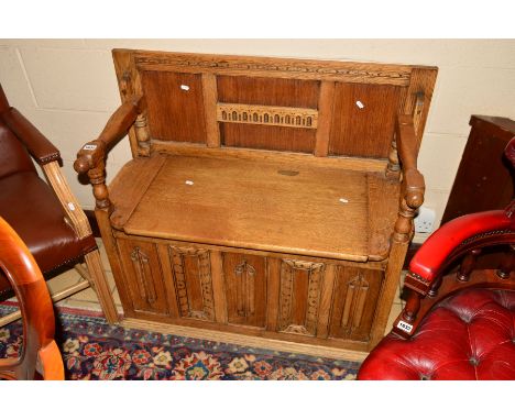 A GOLDEN OAK LINENFOLD MONKS BENCH