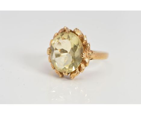 A CITRINE RING, the oval citrine within a laurel wreath style surround, hallmark rubbed, ring size K, approximate weight 3.1 