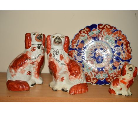 AN ORIENTAL IMARI FLUTED EDGED CHARGER, diameter 31.5cm, together with a pair of Staffordshire seated spaniels, iron red and 