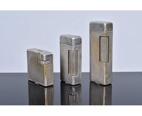 Three silver plated Dunhill pocket lighters, all with engine turned designs, each of a different size and shaped, used, no ov