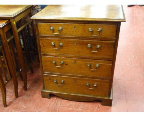 A NEAT ANTIQUE OAK AND MAHOGANY FOUR DRAWER CHEST having a moulded top over four oak lined drawers with antique style swan ne