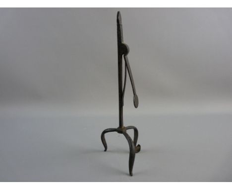 AN 18th CENTURY TRIPOD IRON RUSH LIGHT HOLDER opening via a simple spring to the column, 28 cms high