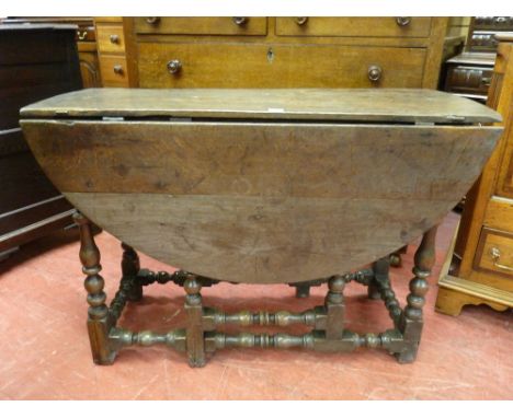 AN 18th CENTURY OAK OVAL TOPPED DROP LEAF GATE LEG DINING TABLE on turned and block supports and with iron hinges