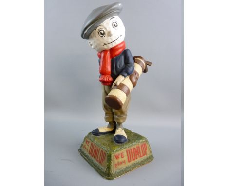 A DUNLOP CADDY GOLFING FIGURE, mounted on a naturalistic square base to inset panels with raised lettering, titled 'We Play D