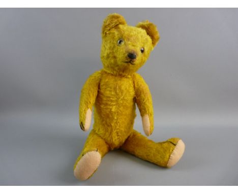 A VINTAGE MOHAIR TEDDY BEAR, gold colour and straw filled with moveable head and limbs, with humpback, (play worn, pads repla