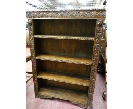 A CARVED OAK FOUR SHELF BOOKCASE, open fronted with lunette and floral decoration, 83 cms wide
