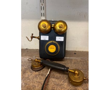 A wall mounted candlestick telephone 