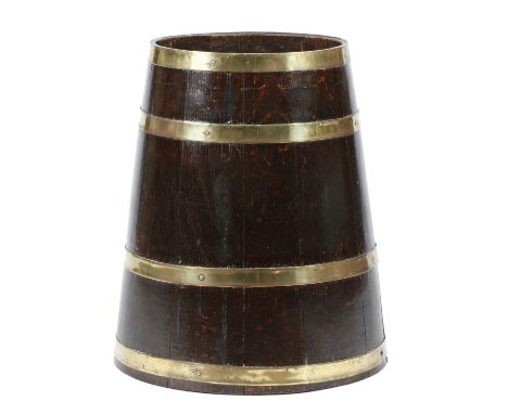 A COOPERED OAK AND BRASS BOUND STICK STAND LATE 19TH / EARLY 20TH CENTURY of milk churn form, the base with an applied metal 