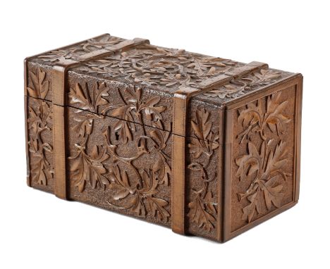 A BLACK FOREST LINDEN WOOD BOX IN THE FORM OF A TRUNK LATE 19TH CENTURY relief carved with scrolling oak leaves and acorns on