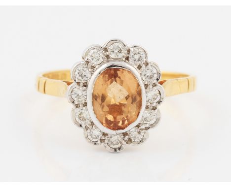 An 18ct yellow gold topaz and diamond cluster ring, set with a central oval cut orange/brown topaz, measuring approx. 7x5mm, 