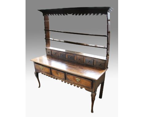 An early 19th Century Georgian oak welsh dresser with three drawers plus wave design skirting, with three shelf open backed t