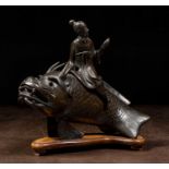 A RARE CHINESE BRONZES FIGURE OF AN IMMORTAL RIDING A MTHICAL FISH-DRAGON
